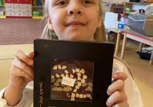 dzieci prezentują swoje gotowe i spakowane czekolady